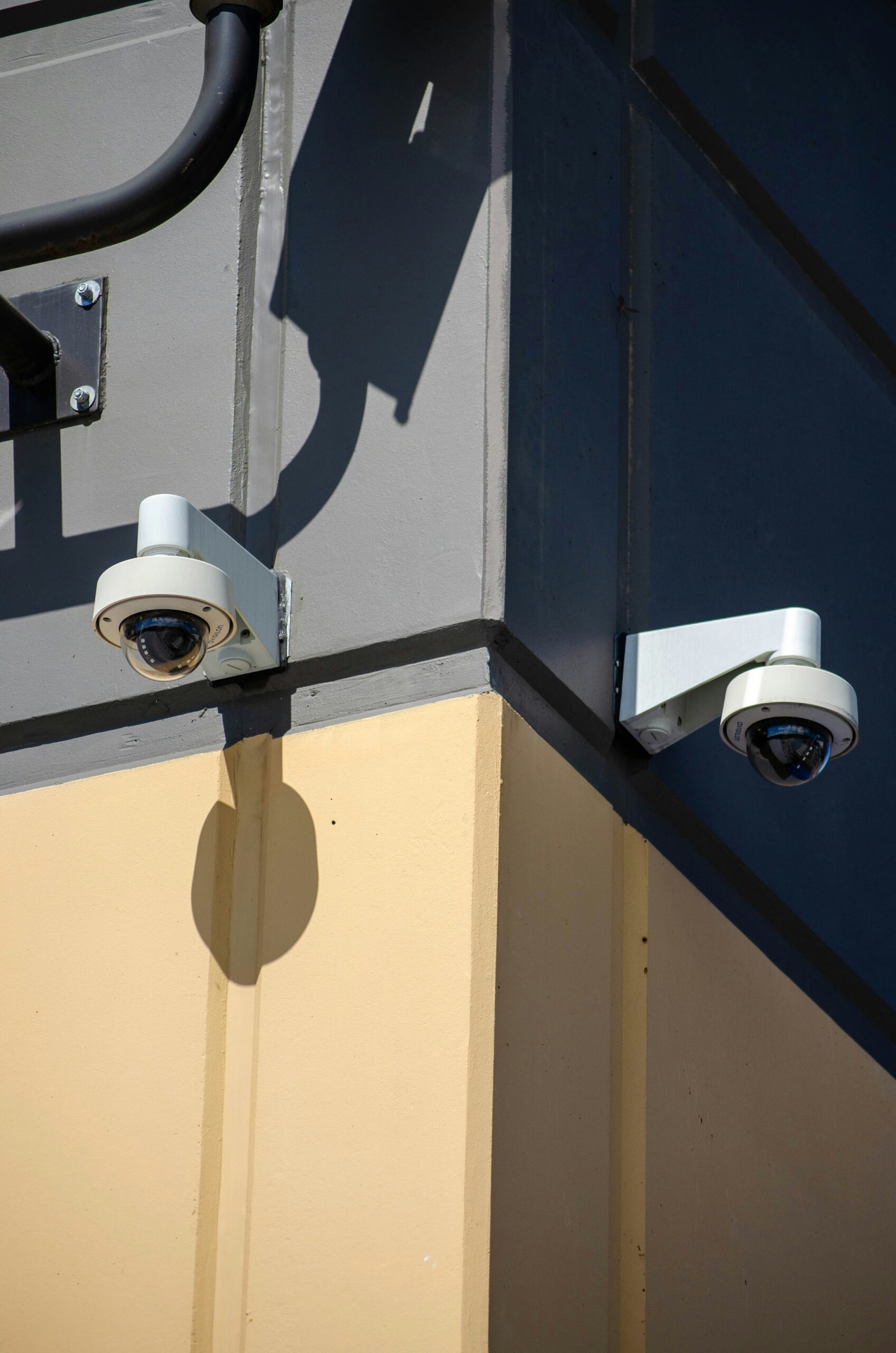 A couple of security cameras mounted to the side of a building